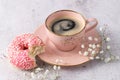 Biten pink glazed donut with sprinkles and vintage coffee cup on stone table Royalty Free Stock Photo