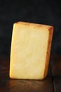 Bitesize Slice of smoked cheddar cheese on rustic wooden background Royalty Free Stock Photo