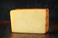 Bitesize Slice of smoked cheddar cheese on rustic wooden background Royalty Free Stock Photo
