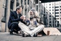 Beaming good-looking man having pleasant conversation with dirty homeless