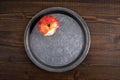 Bitten apple on a metal plate. Dark wood texture table Royalty Free Stock Photo