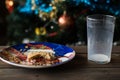 Bitten biscuit, crumbs and a empty glass of milk