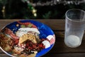 Bitten biscuit, crumbs and a empty glass of milk on a Christmas tree background