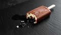Bitten Chocolate Covered Ice Cream Bar on Dark Stone Surface with Meltdown Royalty Free Stock Photo