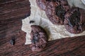 Bitten dark chocolate chip cookies on baking paper over wooden rustic background