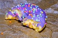 Bitten glazed donut with colorful sprinkles. Lying flat. Food concept. Macro concept. Sugar is bad for health Royalty Free Stock Photo