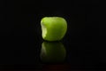 Bitten green apple with reflection on black background Royalty Free Stock Photo
