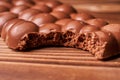 Bitten milk chocolate bar on wooden background Royalty Free Stock Photo