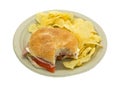 Bitten salami sub sandwich on plate with chips Royalty Free Stock Photo