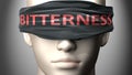 Bitterness can make things harder to see or makes us blind to the reality - pictured as word Bitterness on a blindfold to
