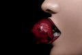 Bitting a rose in red lips on black bakcground Royalty Free Stock Photo