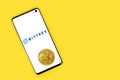 Bittrex icon on phone with Bitcoin on yellow background