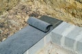 Bituminous waterproofing roll material is laid on wall of concrete blocks