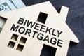 Biweekly mortgage. Wooden model of house and money