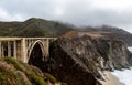 Bixby Bridge along Big Sur Rocky Coastline with Pacific Ocean Waves and Cloudy Sky Royalty Free Stock Photo