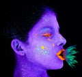 Bizarre beauty. a young woman posing with neon paint on her face. Royalty Free Stock Photo