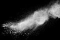 Bizarre forms of white powder explosion cloud against black background.White dust particles splash