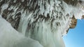 Bizarre icicles hang from the ceiling of a stone grotto in the rock Royalty Free Stock Photo