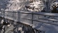 Frozen bridge full of icicles with stream and waterfall Todtnauer WasserfÃÂ¤lle in background in snow-covered forest in winter. Royalty Free Stock Photo