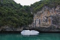 A bizarre rocky island forms an arch over the water of Halong Bay.