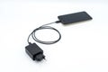 Black AC charger and USB cable connected to mobile phone Royalty Free Stock Photo