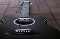 Black acoustic guitar on the brick floor. Closeup top-down photo. Royalty Free Stock Photo