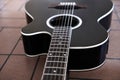 Black acoustic guitar on the brick floor. Closeup top-down photo. Royalty Free Stock Photo