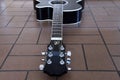 Black acoustic guitar on the brick floor. Closeup top-down photo. Royalty Free Stock Photo