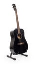Black acoustic guitar on stand, isolated Royalty Free Stock Photo