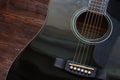 Black acoustic guitar on wooden background Royalty Free Stock Photo