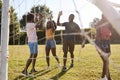 Black adult friends high five during a fun game of football