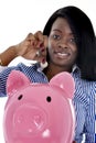 Black African American business woman putting coin into huge pink piggybank Royalty Free Stock Photo