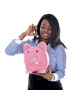 Black African American business woman putting coin into oversized pink piggybank