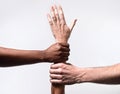 Black African American and Caucasian hands holding together white skin arm in world unity