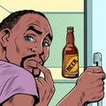 a black african american man near the refrigerator with beer. Alcohol addiction