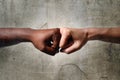 Black African American race female hand touching knuckles with white Caucasian woman in multiracial diversity