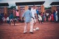 Black african children, boys and adults playing soccer with caucasian volunteers Royalty Free Stock Photo