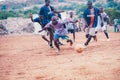 Black african children playing soccer in a rural area