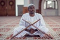 Black African Muslim Man Is Praying In The Mosque with open holy book of Koran Royalty Free Stock Photo