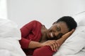 Black African woman laying in bed, smiling and looking at camera Royalty Free Stock Photo