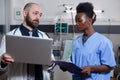 Black afro american asisstant in uniform working with caucasian doctor in hospital ward Royalty Free Stock Photo