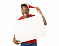 Black afro american man in Christmas Santa hat smiling happy showing blank billboard copy space Royalty Free Stock Photo