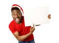 Black afro american man in Christmas Santa hat smiling happy showing blank billboard copy space Royalty Free Stock Photo