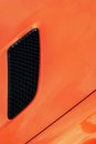 Black air intake grid of orange sport turbo car Royalty Free Stock Photo