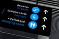 Black airport terminal sign with blue symbols