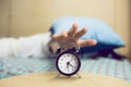 Black Alarm Clock With Blurred Sleeping Young Woman Royalty Free Stock Photo