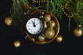 Black Alarm clock and fir tree branch, gold christmas decorations green velours glitte, shine background. Eve Time Concept on tabl