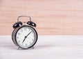 Black alarm clock on old woodden table background.