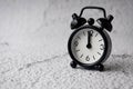 Black alarm clock pointing at 12pm. Copy space and time concept Royalty Free Stock Photo