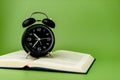 black alarm clock Put on an open book, reading ideas and reading time